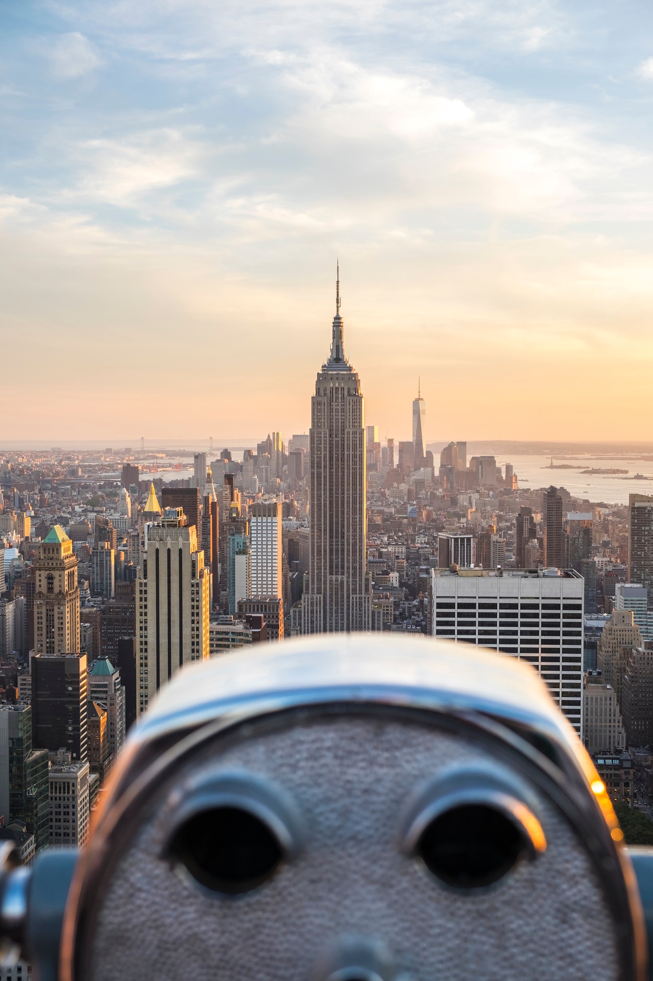 Cityscape of manhattan at dusk, with coin operated binoculars in the foreground.