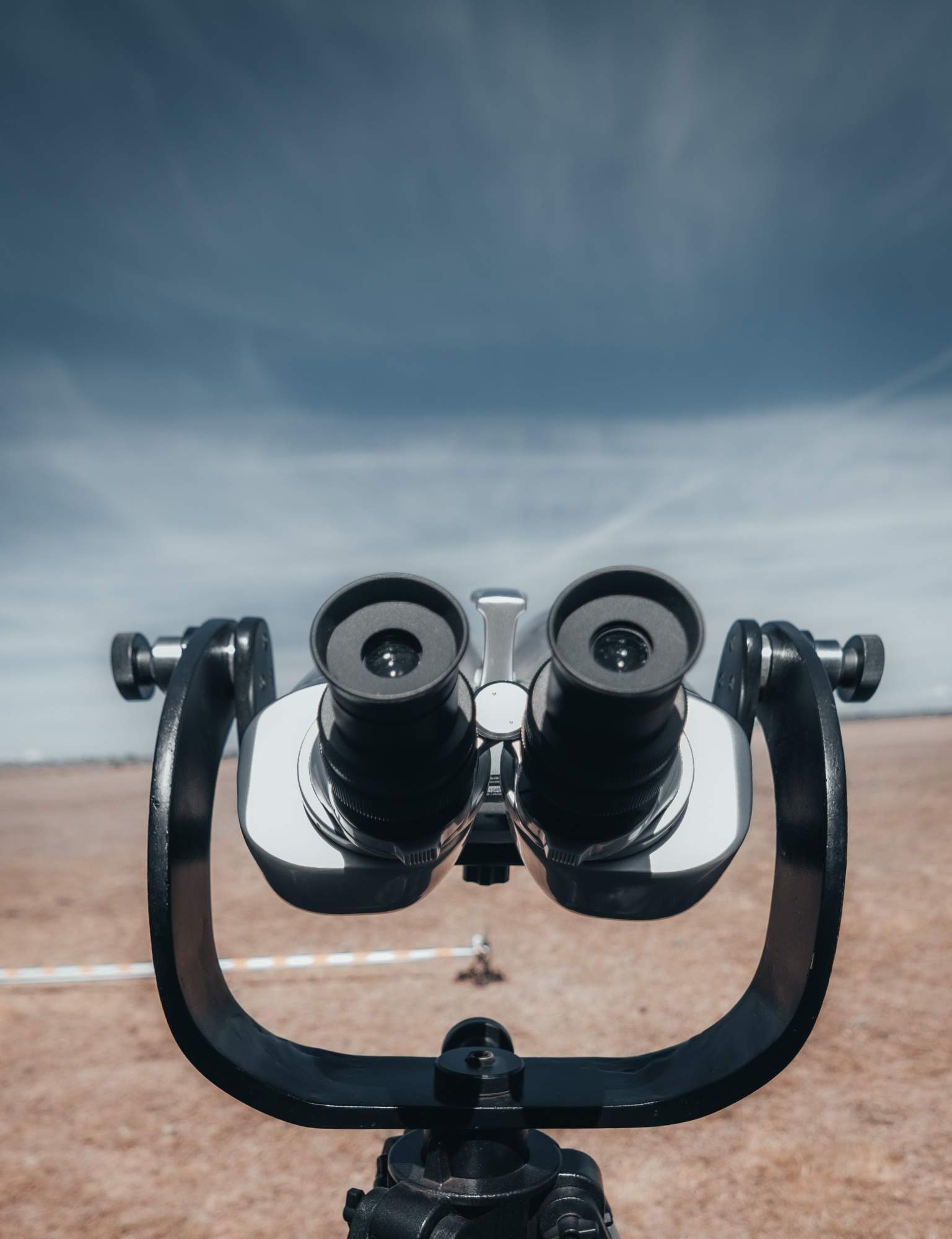 Local seo optimization 1 seo, web design & marketing agency Closeup vertical shot of a public binoculars on a blue sky and dry grassland backgrounds