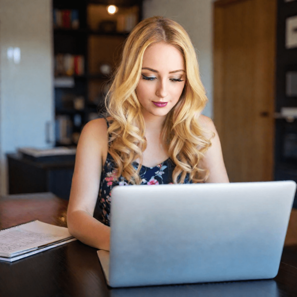 a woman sitting at a table with a laptop