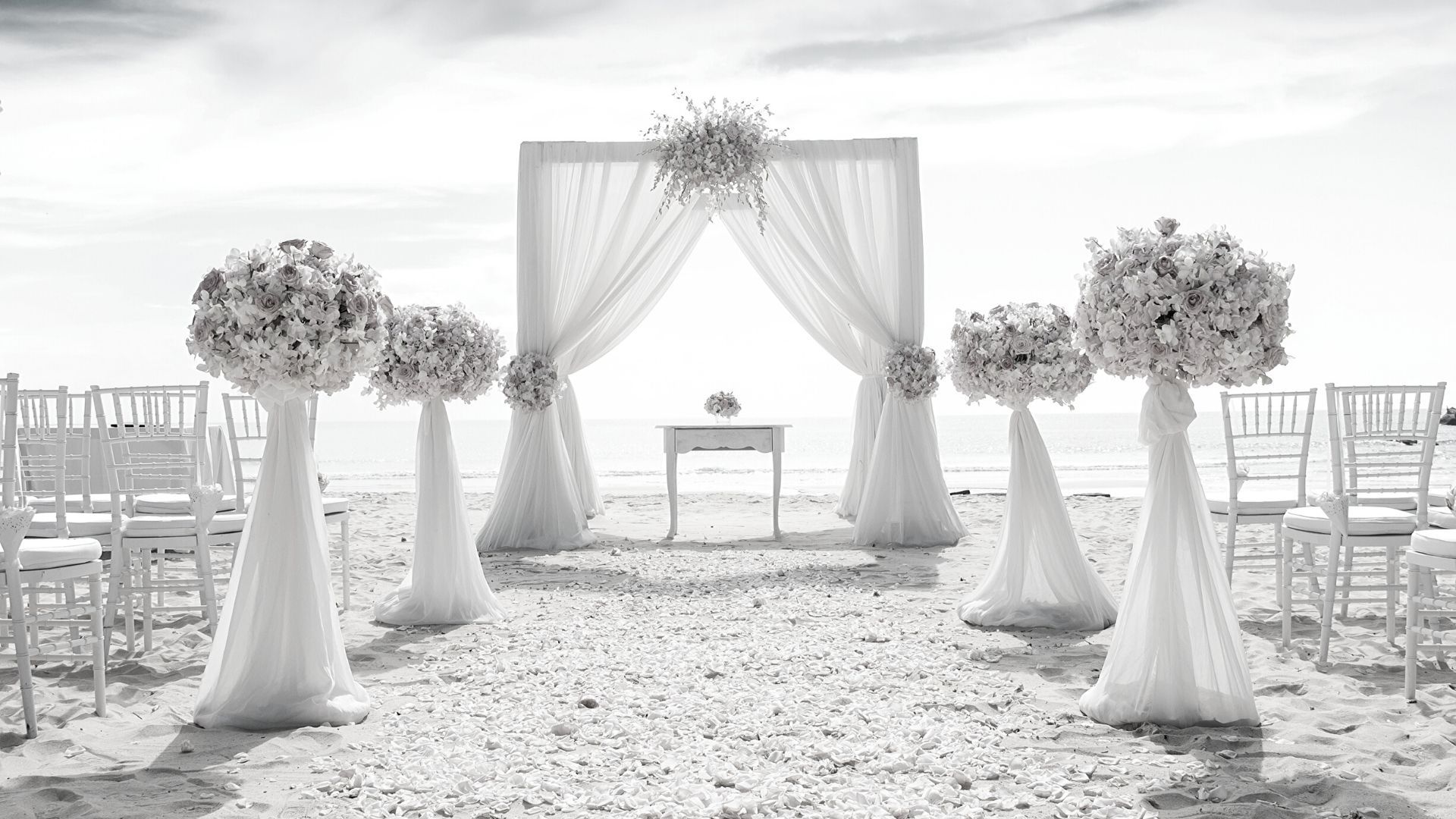 an outdoor ceremony setup with white drapes and flowers