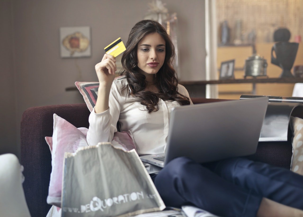 a woman sitting on a couch holding a credit card