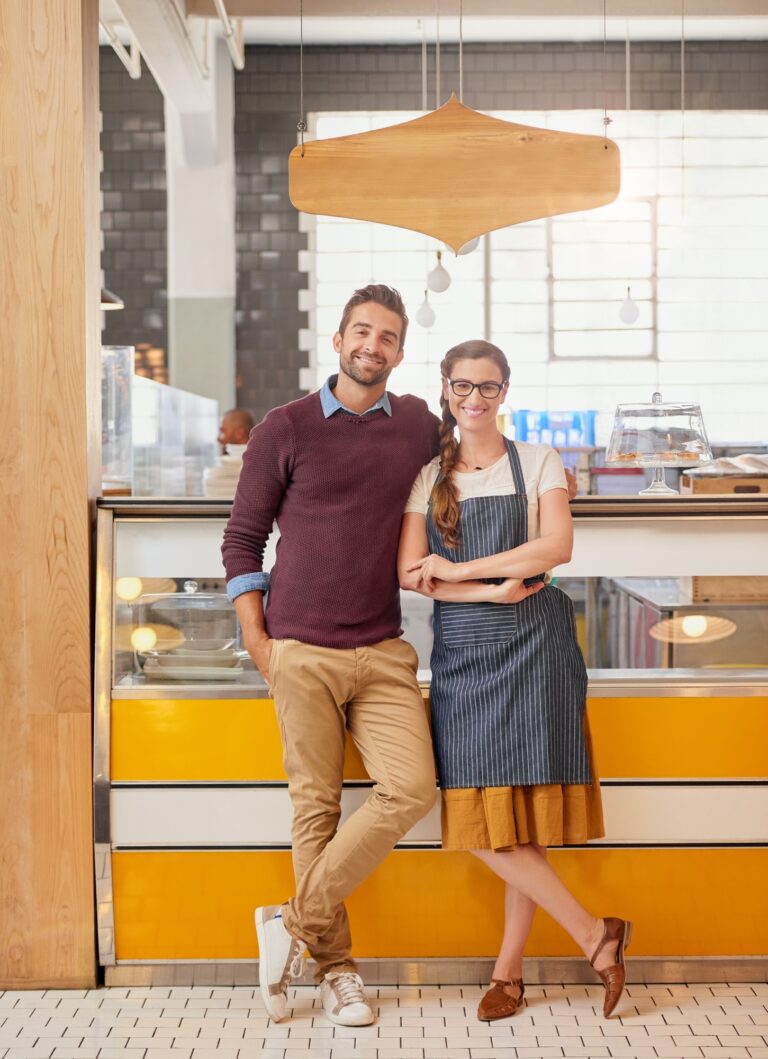 Town press media 12 seo, web design & marketing agency town press media Portrait of two young business owners posing in front of the counter in their coffee shop