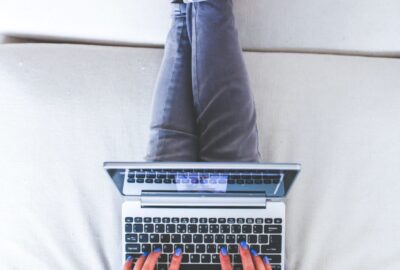a person laying on a bed using a laptop computer